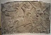 Relief cu doi cavaleri asirieni care atacă dușmani; circa 728 î.Hr,; gips; înălțime: 129&nbsp;cm, lățime: 183 cm; British Museum (Londra)