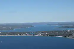 Aerial view of the town from above Lake Michigan; the small lake in the center is Round Lake and the larger one in the background is Lake Charlevoix.