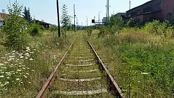 Calea ferată Câmpina–Telega în gara Câmpinița. Clădirile gării sunt în stânga, rafinăria „Steaua Română” în dreapta.