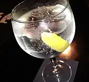 Un gin tonic cu gheață și felie de lămâie
