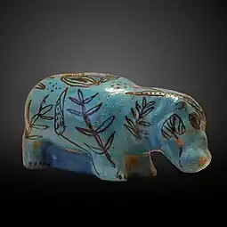 Un hipopotam decorat cu plante acvatice, realizat din faianță cu o glazură albastră. (2033–1710 î.Hr.)
