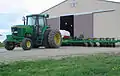 A John Deere 7800 tractor attached to a corn planter.
