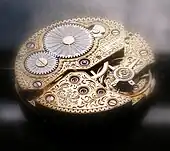 Acante foarte stilizate gravate pe mecanismul unui ceas