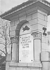 Coloana din piatră cu placa de marmură din zidul incintei bisericii (înainte de 1980).