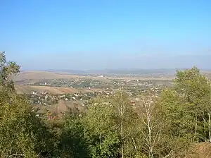 Spre Dobreni (în planul II) şi Mănăstirea Sfântul Vasile (planul III) de pe culmea dealului rezervaţiei