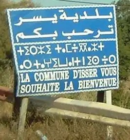 Panou cu un mesaj de bun venit, redactat în trei limbi: limba arabă, berberă și limba franceză, în comuna Isser (Boumerdès, Algeria)