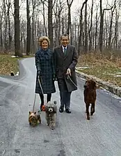 Richard și Pat Nixon își plimbă câinii la Camp David.
