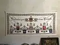 Inscripția Siebenbürgen süsse Heimat (i.e. Transilvania, patrie dulce), pe un covor tradițional săsesc de la biserica fortificată din Axente Sever (în trecut Frâua, în germană Frauendorf)