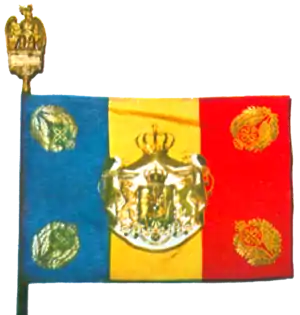 Drapel de luptă tricolor din vremea celui de-Al Doilea Război Mondial, având la colțuri Cifra Regală a  Majestății Sale Regelui Mihai I încununat cu frunze de laur