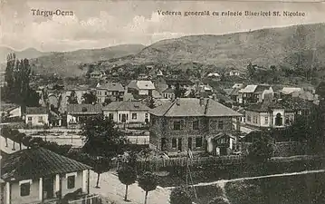 Biserica avariată, în planul depărtat din stânga. Fotografie din anul 1920.
