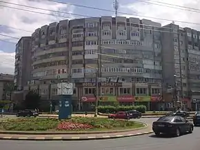 Sensul giratoriu situat la intersecția între Calea Unirii și Calea Burdujeni. Această intersecție este considerată centrul cartierului Burdujeni, reprezentând punctul comun al celor trei subcartiere de blocuri ridicate în perioada regimului comunist: Cuza Vodă I, Cuza Vodă II și Cuza Vodă III. Blocul din imagine face parte din Cuza Vodă III.