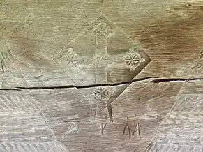 Crucea şi anul construcţiei bisericii, sculptate în partea superioară a portalului de la intrare.