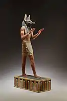 Statuetă a lui Anubis; 332–30 î.Hr.; lemn pictat, și cu ipsos; 42,3 cm; Muzeul Metropolitan de Artă