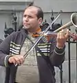 Muzicant ambulant cântând la vioară cu goarnă în Anvers