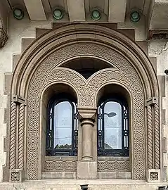 Ferestre neoromânești ale Casei Gheorghe Petrașcu, decorate cu o bandă de antrelacuri, în București