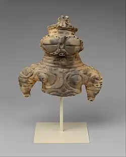 Dogū; 1000–300 î.Hr.; ceramică; înălțime: 16,5&nbsp;cm, lățime: 16,2&nbsp;cm, adâncime: 7,9&nbsp;cm; Muzeul Metropolitan de Artă (New York City)