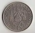 Piesă de 50 F CFP (XPF) (Noua Caledonie); revers: circular, NOVVELLE CALEDONIE, colibă „kanak”, înconjurată de trei pini colinari şi de un cocotier, valoarea nominală, 50 f