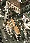 Biserica Mátyás (vedere aeriană) şi în stânga sus Piaţa Sfintei Treimi (Szentháromság tér) cu Coloana Sfintei Treimi construită în 1713