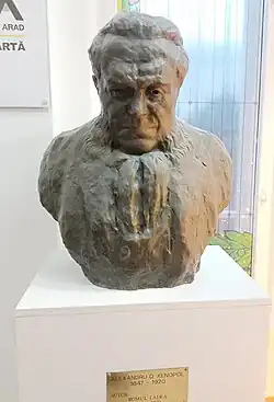 Bustul lui A. D. Xenopol sculptat de Romul Ladea, aflat în holul Bibliotecii Județene „Alexandru D. Xenopol” din Arad