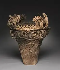Vas în „stilul cu flăcări”; din perioada Jōmon a Japoniei; c. 2750 î.Hr.; ceramică cu ornamente decorate și aplicate; înălțime: 61&nbsp;cm, diametru: 55,8&nbsp;cm; Muzeul de Artă din Cleveland