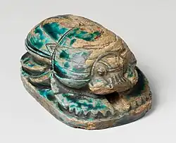 Scarabeu comemorativ al lui Amenhotep al III-lea; 1390–1352 î.Hr.; steatit cu glazură albastră; lungine: 8 cm; Muzeul Metropolitan de Artă
