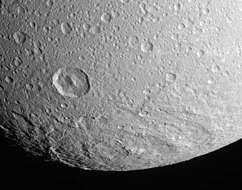 South polar impact basin Evander, 350&nbsp;km in diameter, is by far the largest crater on Dione. The deep crater to its upper left is Sabinus.