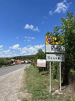 Inscripție bilingvă româno-germană la intrarea dintr-un sat din Transilvania (Ruși)