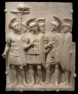 Relieful cu Pretorieni; circa 51–52; marmură; 163 × 134 × 28 cm; Louvre-Lens (Lens, Franța)