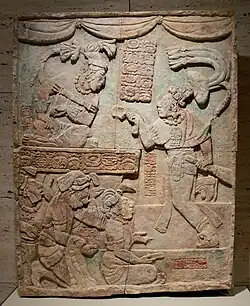 Relief în care apare Aj Chak Maax prezentând prizonieri înaintea conducătorului Itzamnaaj B'alam al III-lea din Yaxchilan; 22 august 783; calcar cu urme de pigment; înălțime: 1,15 m; Muzeul de Artă Kimbell (Fort Worth, Texas, SUA)