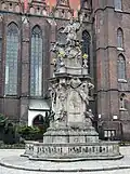 Monumentul Sfântului Ioan Nepomuk pe fundalul bisericii "Sfânta Cruce și Sfântul Bartolomeu" din cartierul Ostrów Tumski a Wroclaw-ului.