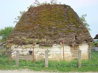 Casă veche din chirpici, acoperită cu paie