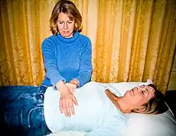 Practicant Reiki oferind tratament unui pacient.