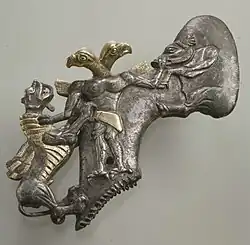 Topor cu un demon cu cap de vultur și animale; mileniul al III-lea târziu-mileniul al II-lea timpuriu î.Hr.; arhint aurit; lungime: 15&nbsp;cm; Muzeul Metropolitan de Artă (New York City)