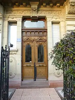 Ușă de lemn cu frontoane, a unei case din 1896, în Strasbourg (Franța). Chiar dacă e neobarocă, are multe elemente neoclasice