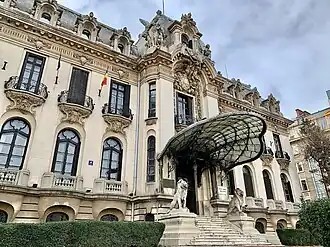 Priveliște a palatului, cu perechea sa de lei în stilul Ludovic al XIV-lea la intrare