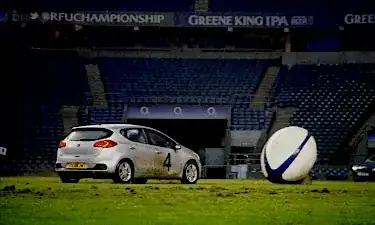 Someone licking a giant rugby a ball by colliding a car against it.