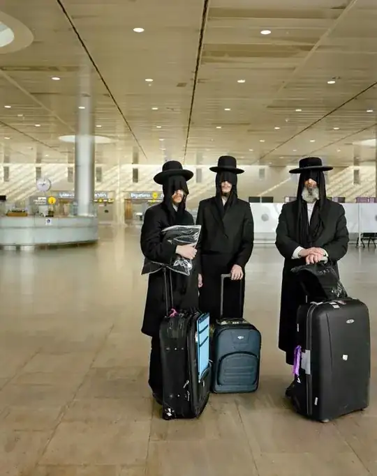 Hasidic men at an airport, wearing blindfolds