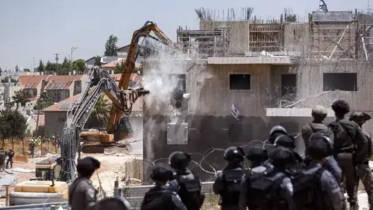 Backhoes demolishing buildings in combat zone